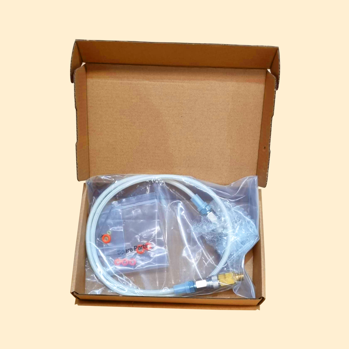 A boxed adapter kit for a rapid infusion machine with metallic connectors and a flexible tube.